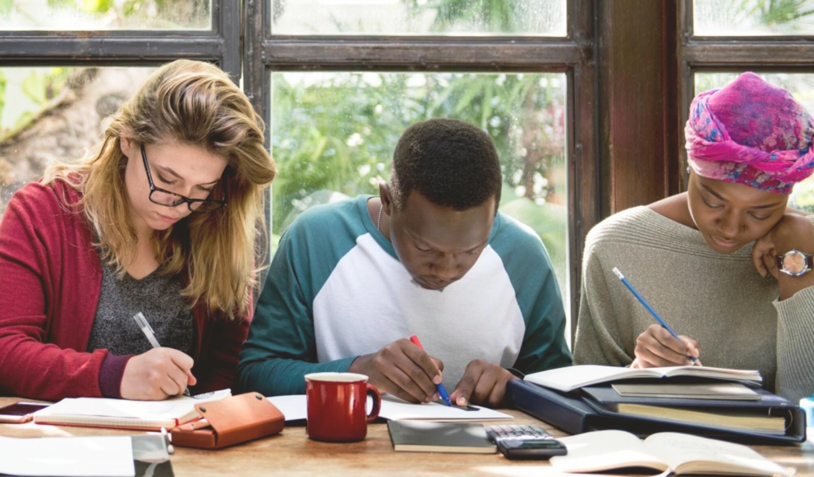 Étudiant analysant des données financières sur plusieurs écrans